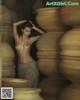 A naked woman standing in front of a pile of clay pots.