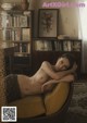 A naked woman sitting on a chair in a living room.