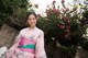 A woman in a pink kimono posing for a picture.