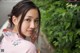 A woman in a pink kimono posing for a picture.