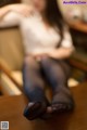 A woman sitting on top of a wooden table.