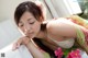 A woman laying on a bed with flowers in her hair.