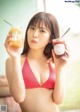 A woman in a red bikini holding a jar of jam.