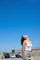 A woman standing in the middle of a parking lot.