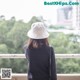 A woman wearing a white hat looking out over a city.