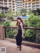 A woman standing on a balcony in front of a building.