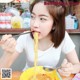 A woman eating a bowl of noodles with chopsticks.