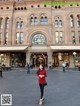 A woman standing in front of a large building.