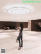 A woman standing in the middle of a large lobby.