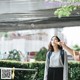 A woman blowing bubbles while standing next to another woman.