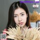 A woman holding a bunch of dried grass in her hands.