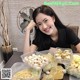 A woman sitting at a table with a bunch of food.