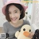 A woman in a pink hat holding a stuffed duck.