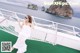 A woman in a white dress sitting in a hammock on a boat.