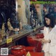 A woman in a white lab coat holding incense sticks in a temple.