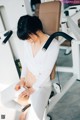 A woman sitting on a bench in a gym.