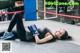 A woman laying on the ground in a boxing ring.