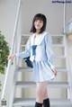 A woman in a school uniform standing on a set of stairs.