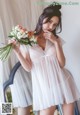 A woman in a white dress holding a bouquet of flowers.