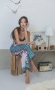 A woman sitting on top of a wooden box.