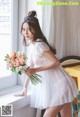 A woman in a white dress holding a bouquet of flowers.