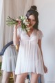 A woman in a white dress holding a bouquet of flowers.