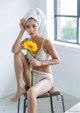 A woman sitting on a chair holding a sunflower.