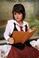 A woman in a school uniform holding a folder.