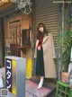 A woman standing in front of a building wearing a coat.