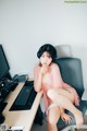 A woman sitting on a chair in front of a computer.