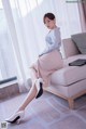 a woman sitting on top of a couch next to a window