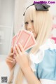 A woman in a maid outfit holding a deck of cards.