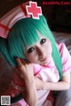 A woman with green hair wearing a pink nurse outfit.