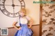 A woman in a blue and white dress posing in front of a clock.