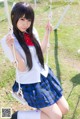 A woman in a school uniform sitting on a swing.