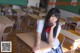 A young woman sitting at a desk in a classroom.