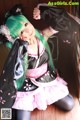 A woman with green hair wearing a black and pink kimono.