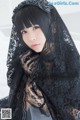 A woman wearing a black lace shawl and gloves.