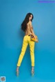 A woman in yellow pants is posing for a picture.