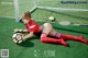 A woman laying on the ground with a soccer ball.