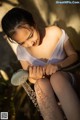 A woman sitting on the ground holding a shower head.