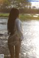 A woman standing in the water with her back to the camera.