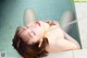 A woman laying in a bathtub with her eyes closed.