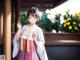 A woman in a kimono standing in front of a building.