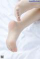 A close up of a woman's bare feet on a bed.