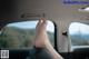 A woman's feet sticking out the window of a car.