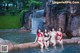 A group of women in bikinis sitting in a pool next to a waterfall.