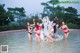 A group of women in bikinis standing in the water.