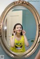 A woman brushing her teeth in front of a mirror.