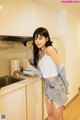 A woman standing in a kitchen holding a spatula.